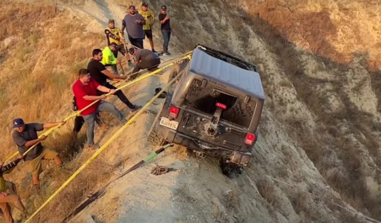 Una Jeep Wrangler rimane in bilico sul crinale di una collina e viene salvata da un gruppo di appassionati Una Jeep Wrangler rimane in bilico sul crinale di una collina e viene salvata da un gruppo di appassionati
