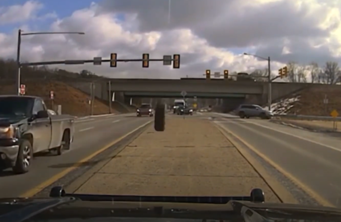 Pneumatico piomba su auto della polizia ferma al semaforo: parabrezza in frantumi [VIDEO]