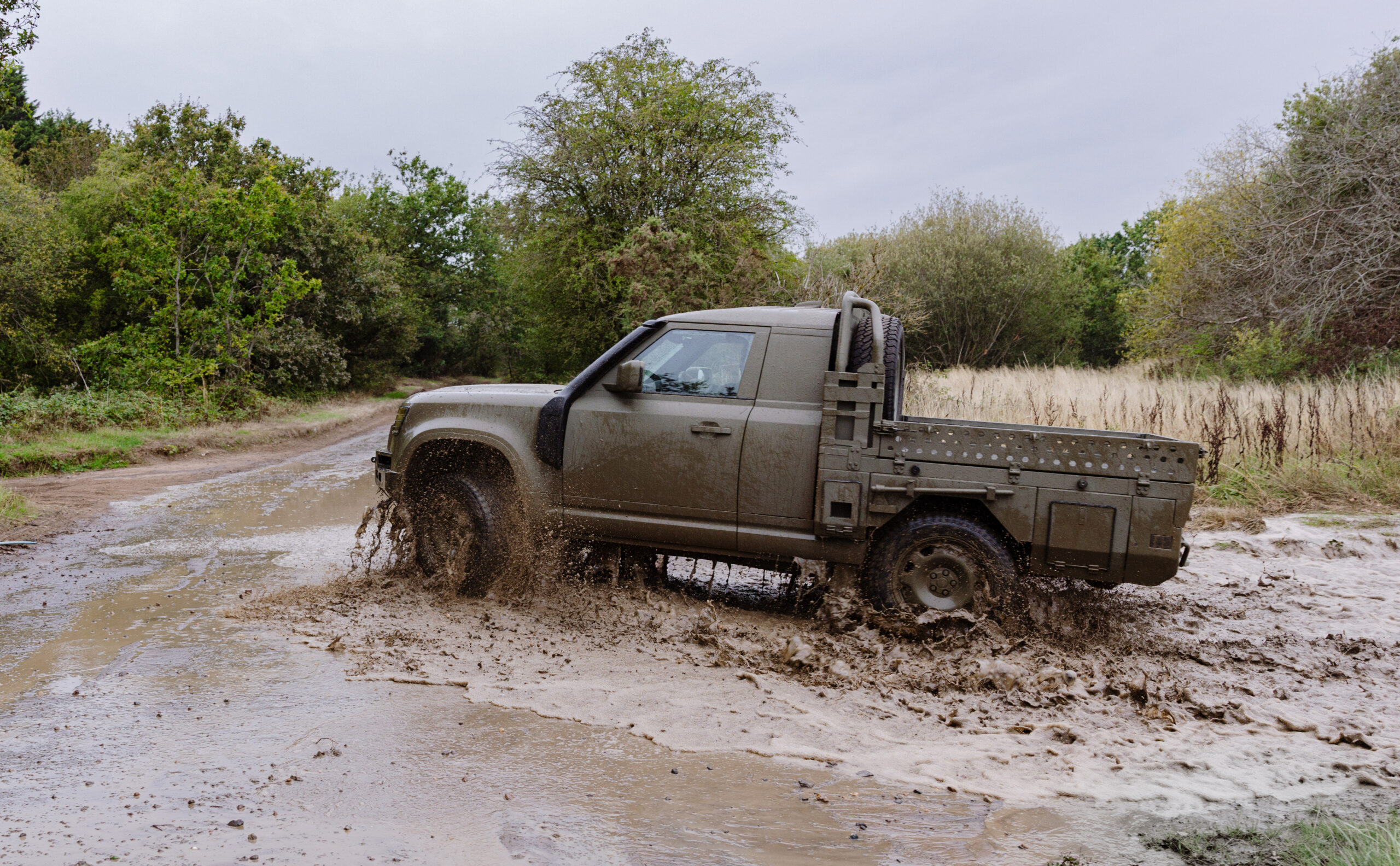 Land Rover Defender Wolf Series II Utility Vehicle in movimento su terreno fangoso