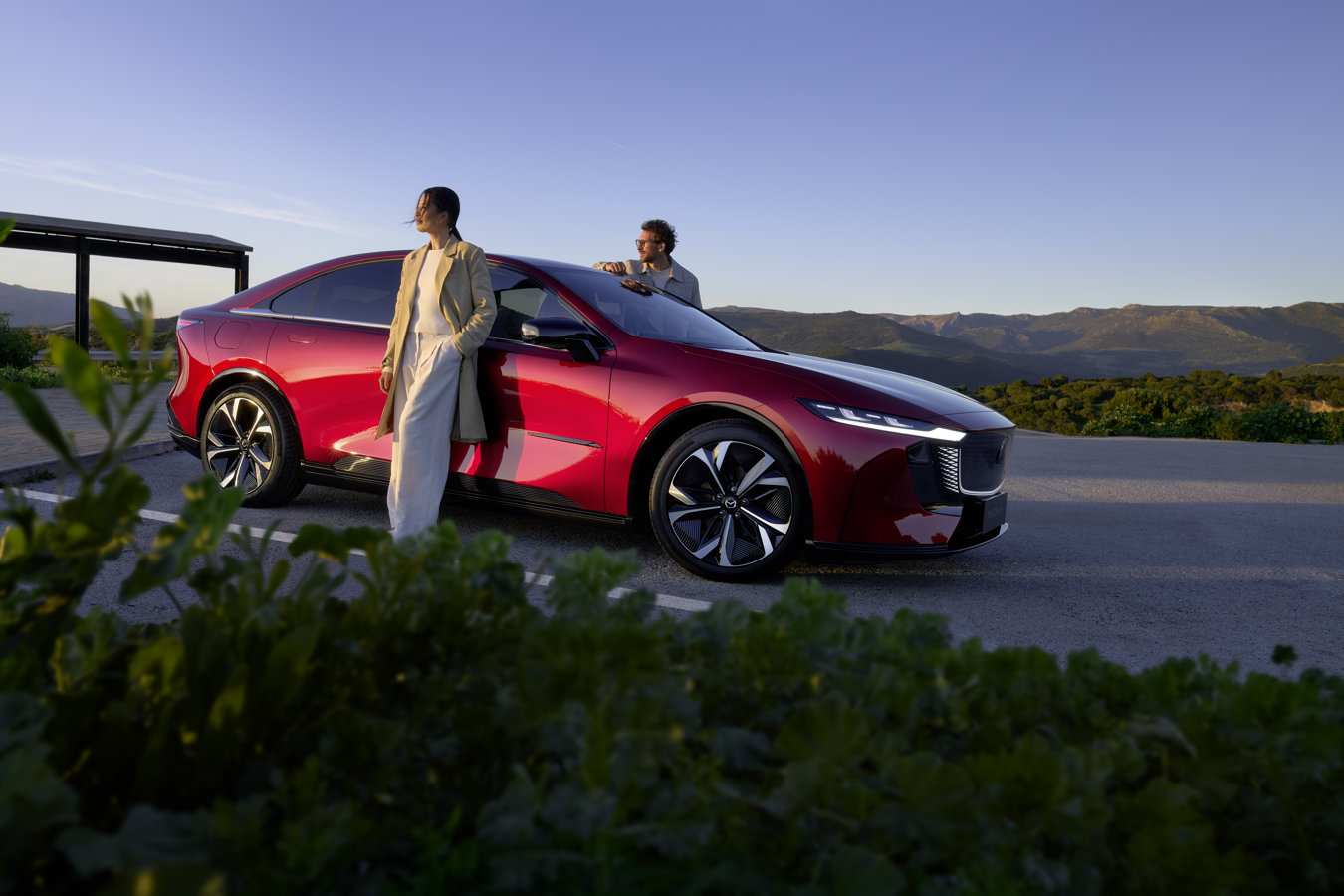 Mazda6e 2027 vista laterale con persone